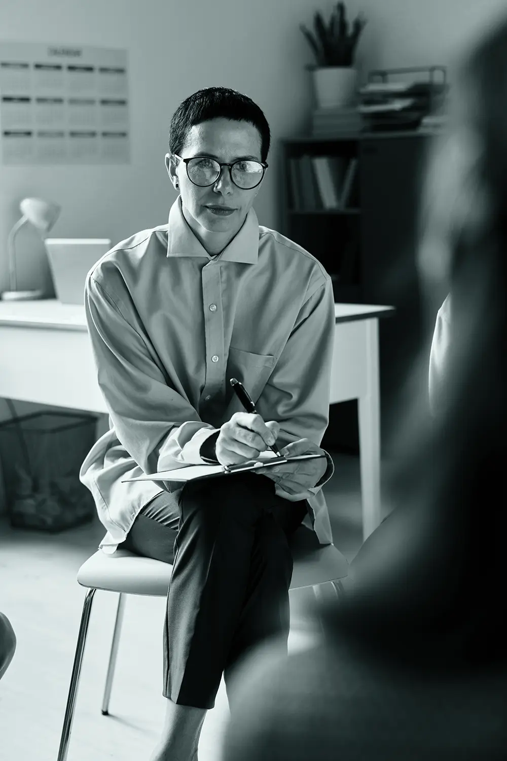 Therapy session female psychologist taking notes in office